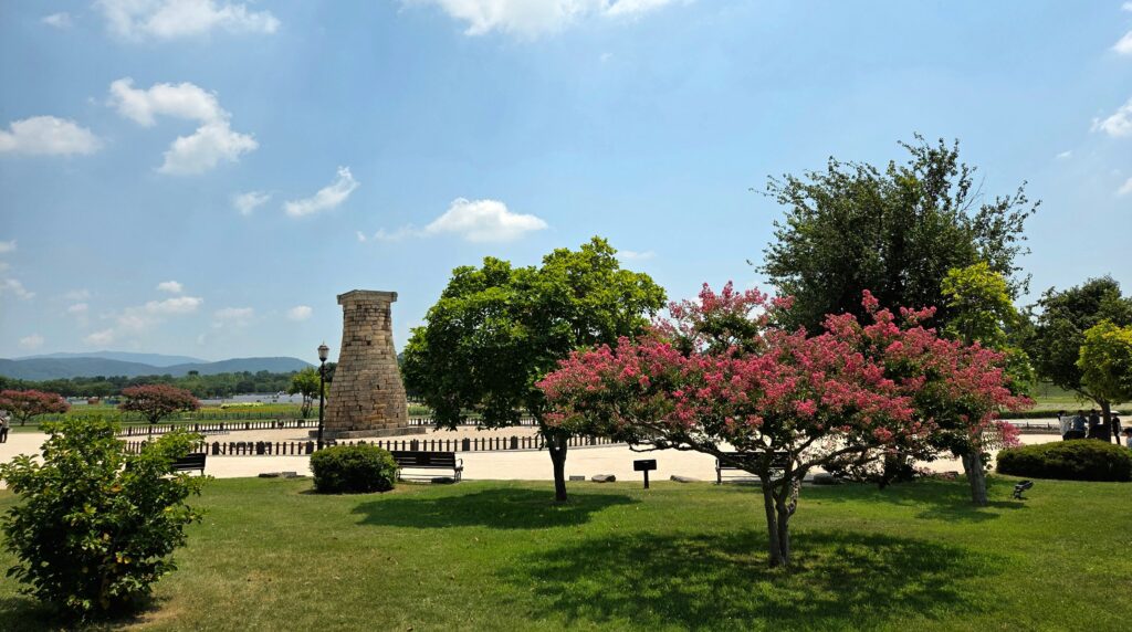 The ancient Cheomseongdae observatory surrounded by vibrant crape myrtle trees in a peaceful park in Gyeongju.