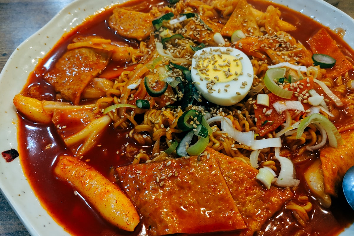 Bowl of Korean rabokki with rice cakes, ramen, egg and spicy sauce