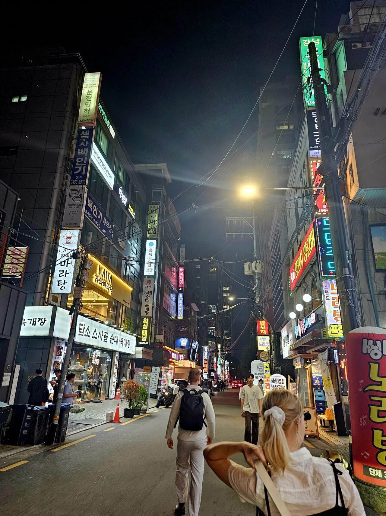 Gangnam restaurant street at night packed with Korean neon signs