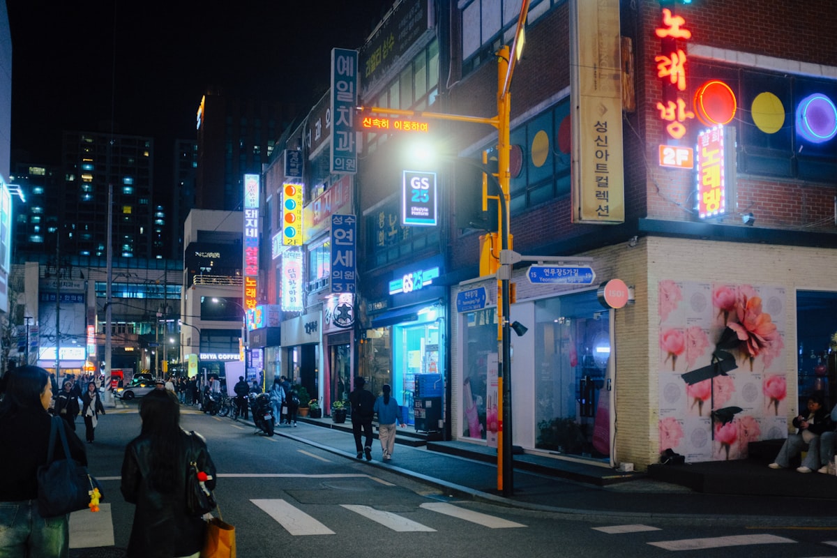 Seoul street corner at night with a GS25 and a neon noraebang sign