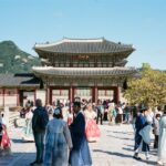 Visitors in hanbok in front of Gyeongbokgung Palace with Bugaksan behind