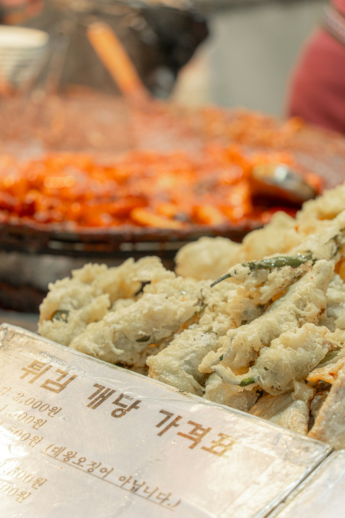 Korean twigim fritters beside a handwritten price list in Korean