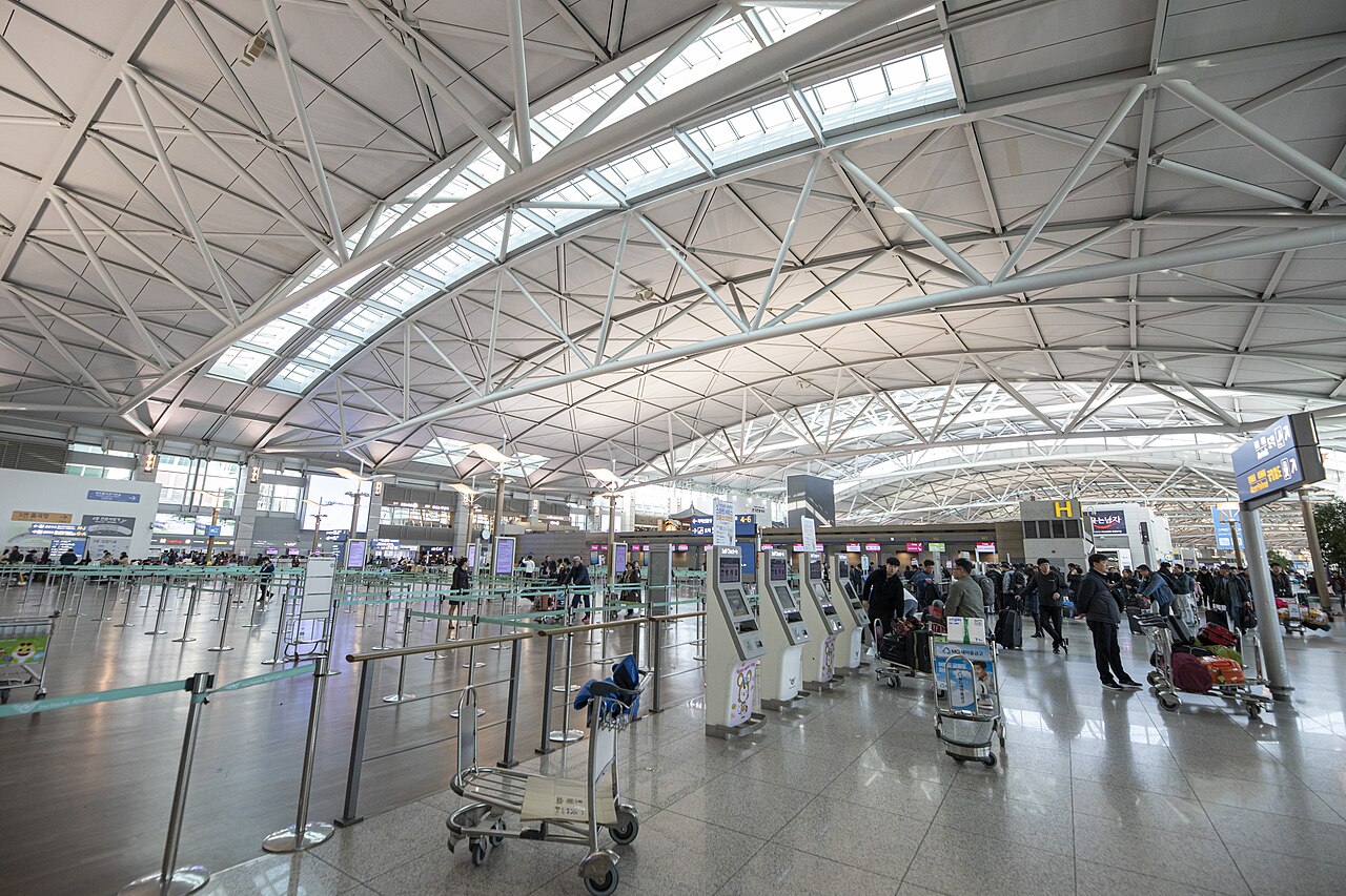Check-in kiosks and Korean signage in the Incheon Airport Terminal 1 departure hall