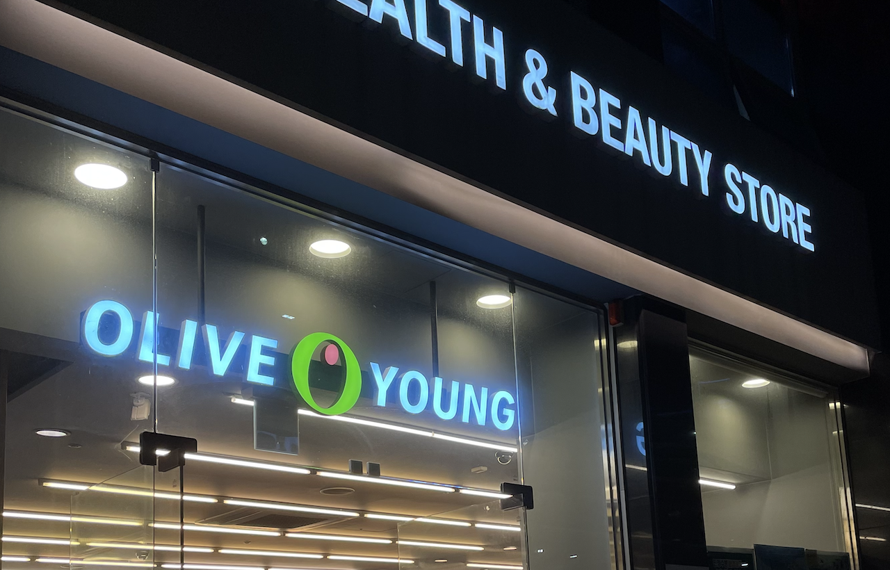 Lit Olive Young health and beauty store sign on a Korean shopping street